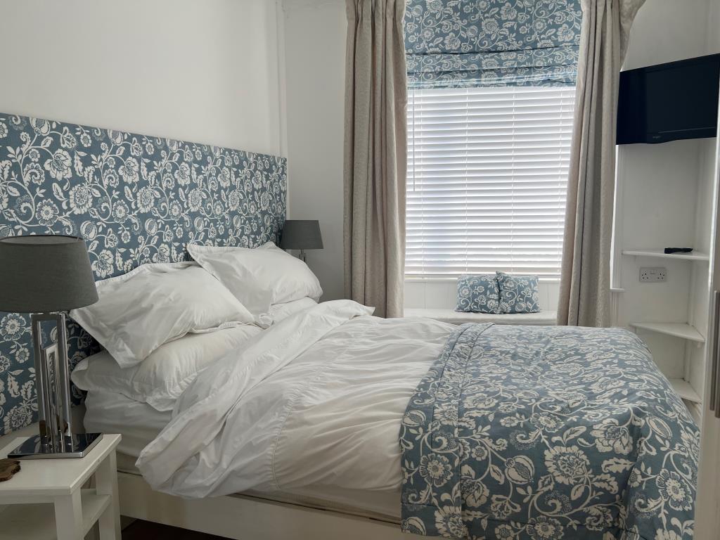 Lot: 144 - COMMERCIAL PROPERTY WITH THREE SELF-CONTAINED LETTING UNITS ENJOYING SEA VIEWS - Trispen - ground floor apartment double bedroom